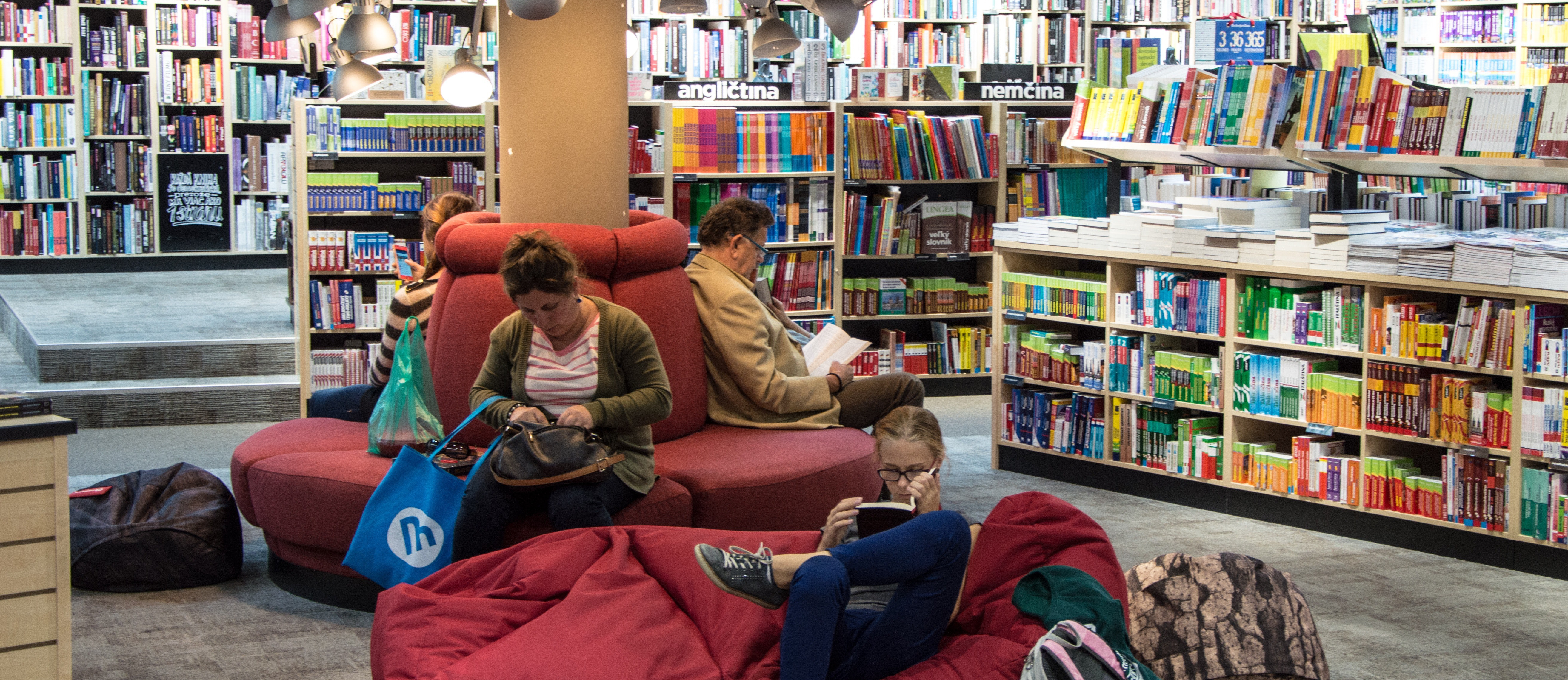 A candid photo of people sitting and reading at a library or book store